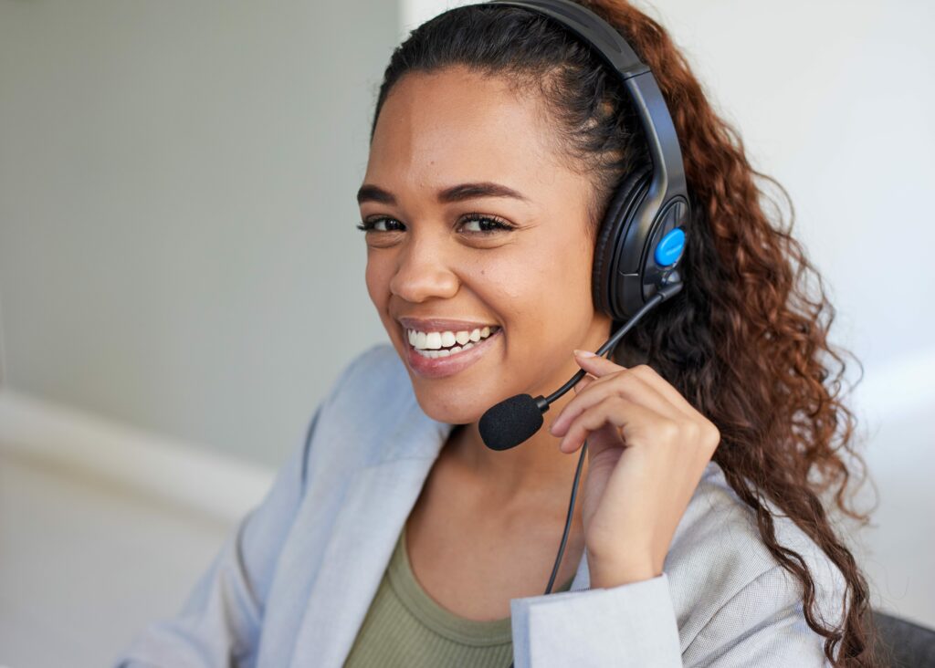 Frau mit Headset lächelt in die Kamera